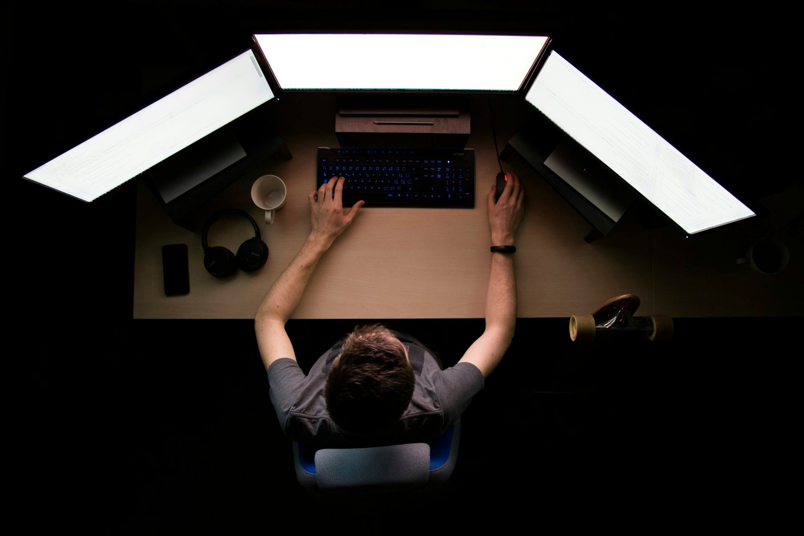 A developer working in front of three monitors
