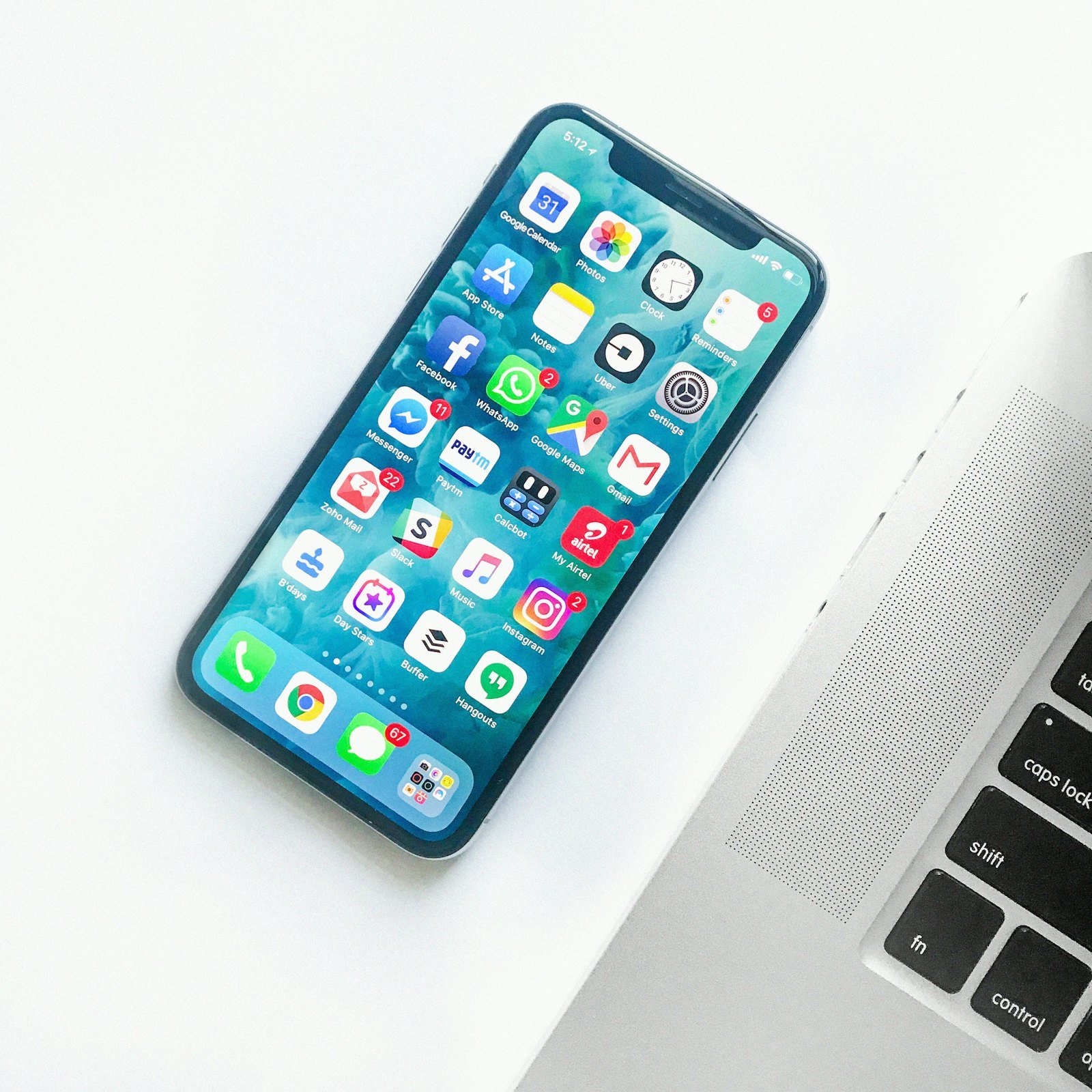 An app interface on a phone next to a laptop